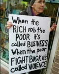 Old lady holding a sign: When the RICH rob the POOR it's called BUSINESS. When the poor FIGHT BACK it's called VIOLENCE.